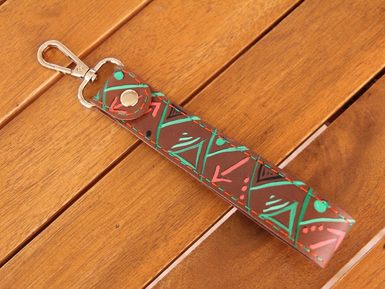 Schlüsselanhänger mit Karabiner, aus Nubukleder in mittelbraun, bemalt mit Streifen in grün und orange