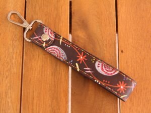 Schlüsselhalter aus Leder in dunkelbraun, Bemalt mit bunten Symbolen, Garnfarbe in rot und gelb