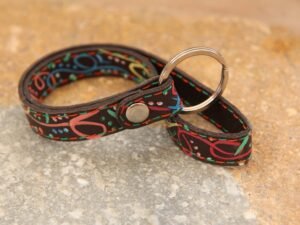 Schlüsselband aus Nubukleder in dunkelbraun mit bunt bemalten Symbolen, Garnfarbe in orange und grün