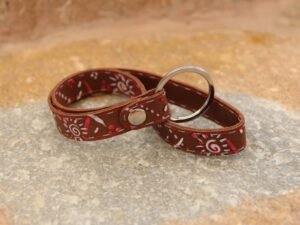 Langes Schlüsselband aus Nubukleder, mittelbraun, bemalt mit bunten Symbolen in rot und rosa, Garnfarbe in rot und flieder