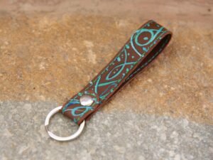 Kurzer Schlüsselanhänger aus Leder in mittelbraun, bunt bemalt, Garnfarbe in grün und blau